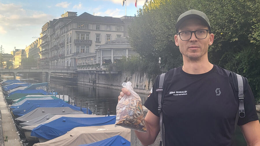 Mischa Gurov with collected cigarette butts at Zurich’s Schanzengraben Mischa Gurov holding a bag of collected cigarette butts beside Zurich’s Schanzengraben during a litter clean-up